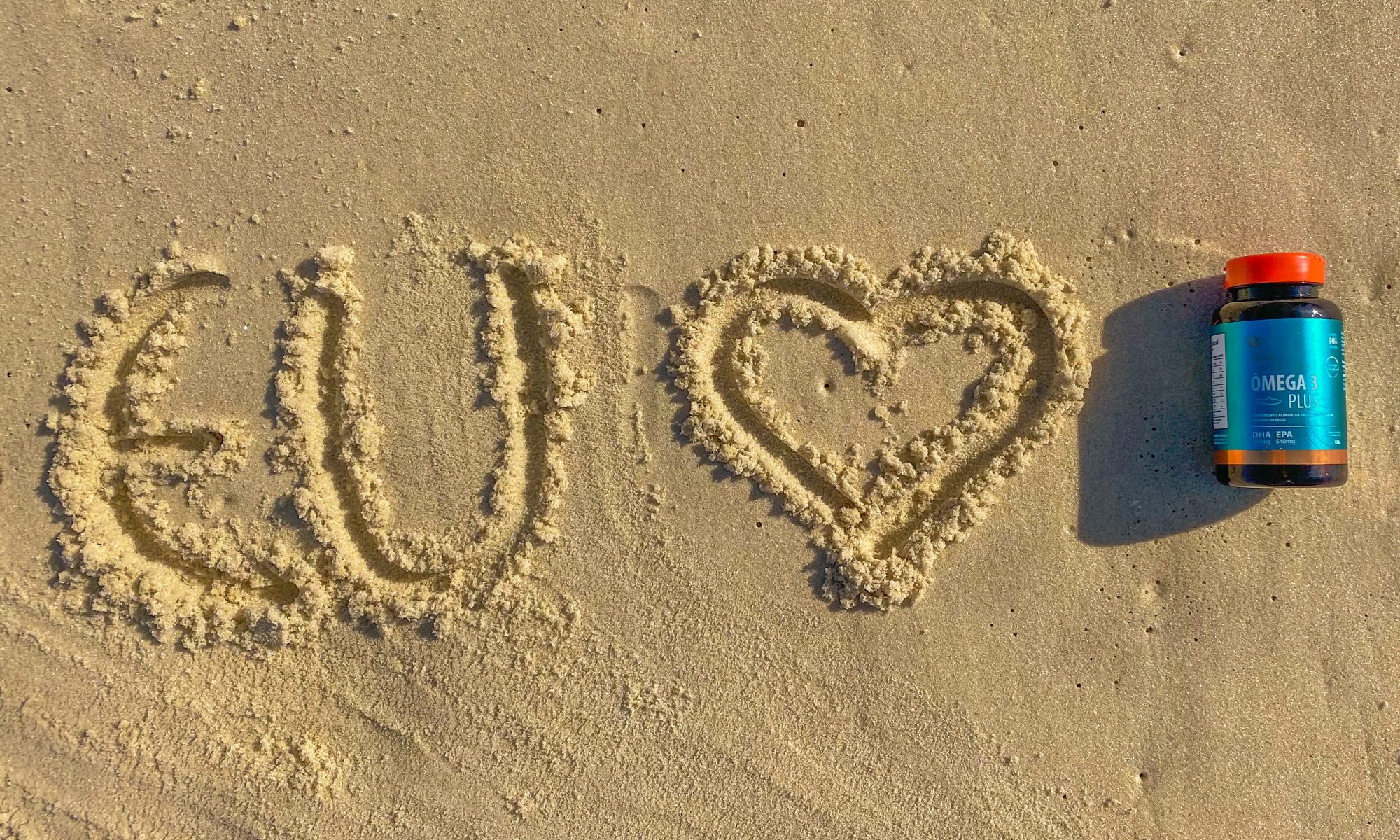 embalagem de ômega 3 um dos suplementos essenciais com mensagem de amor na praia